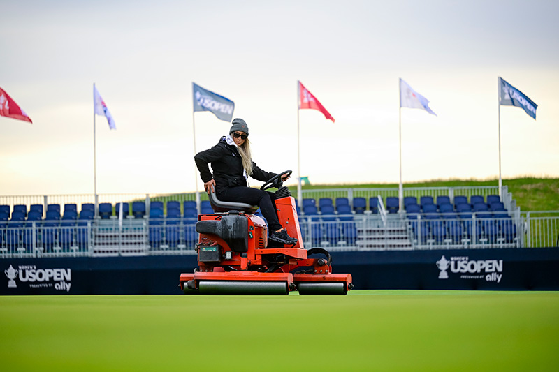 Woman in outdoor gear rolling greens at the U.S. Women's Open
