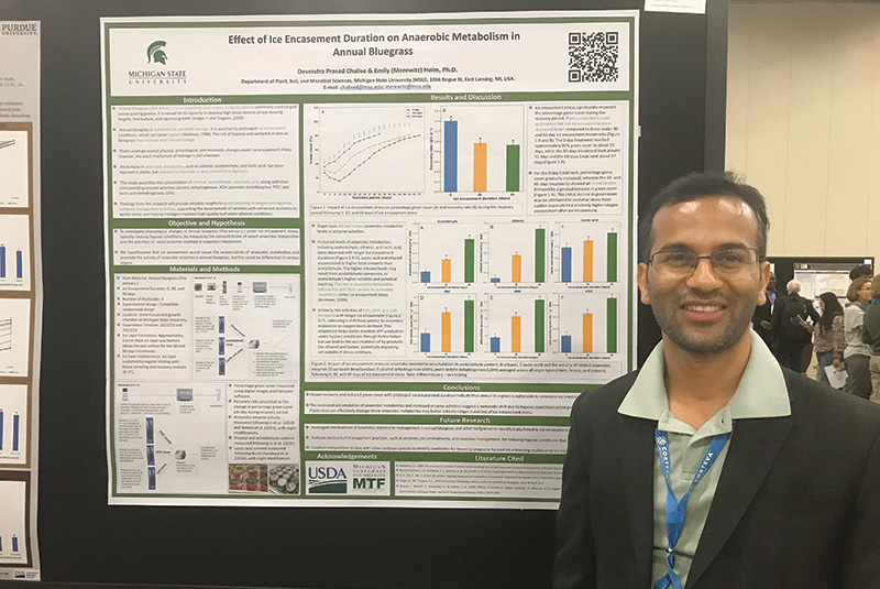 South Asian man standing in front of a research presentation board